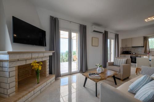 a living room with a fireplace and a tv at Anima Horizon - Elia Villa 