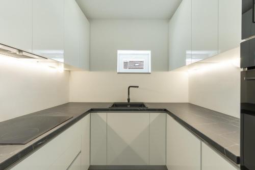 a kitchen with white cabinets and a sink at Villa Marijo with a pool in Novalja