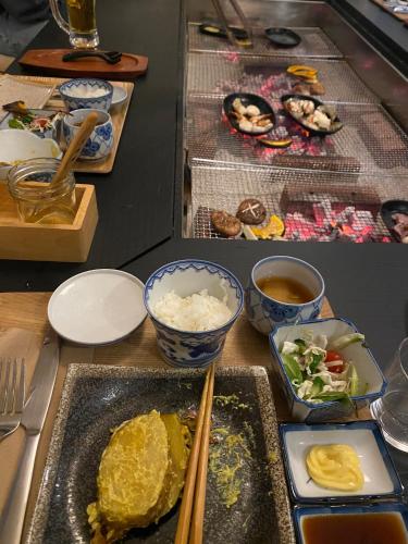 a table with plates of food and bowls of rice at Myoko Forest Lodge in Myoko