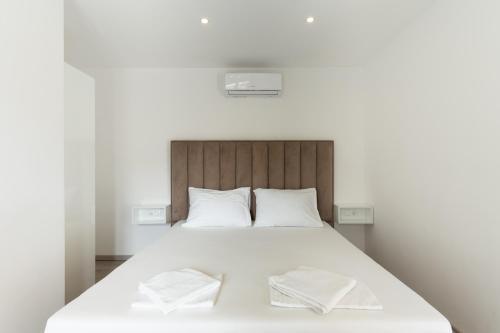 a bedroom with a white bed with two towels on it at Villa Marijo with a pool in Novalja