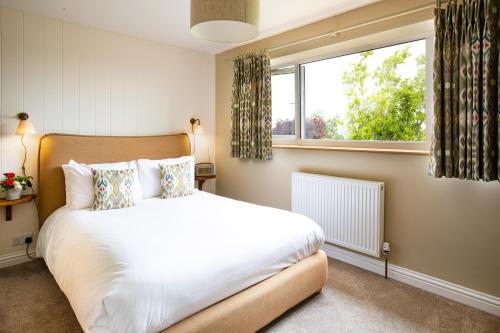 a bedroom with a bed and a window at Wychwood Cottage in Charlbury