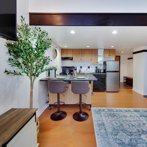 une cuisine avec un îlot et deux tabourets de bar dans l'établissement Cozy Two-story Loft in Downtown, à Vancouver