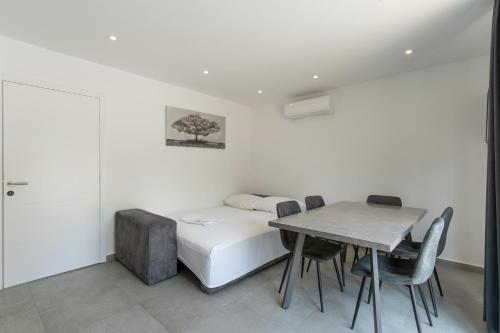 a bedroom with a bed and a table and chairs at Villa Marijo with a pool in Novalja