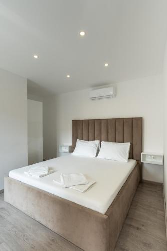 a bedroom with a large bed with white sheets at Villa Marijo with a pool in Novalja