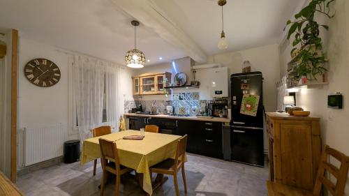 a kitchen with a table with a yellow table cloth on it at Le Nid de Marguerite in Castelnaudary