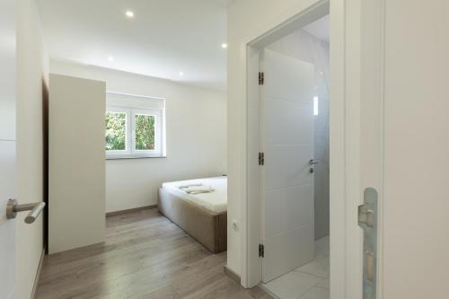 a white room with a bed and a sliding glass door at Villa Marijo with a pool in Novalja