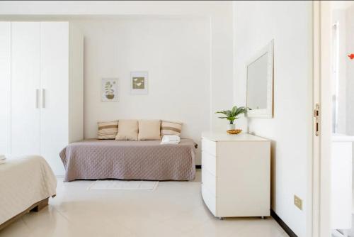 a white bedroom with a bed and a white dresser at Casa in centro con ampio giardino in Pescara