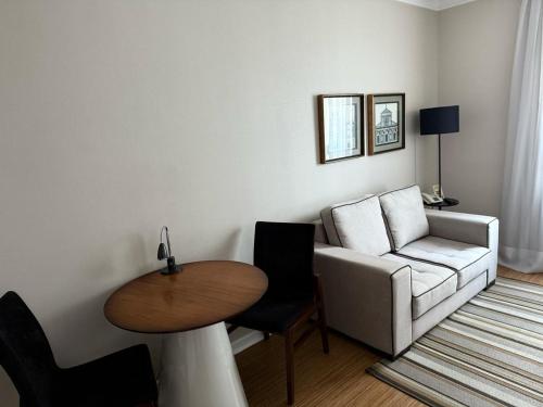 a living room with a white couch and a table at Dream Flat Pinheiros in Sao Paulo