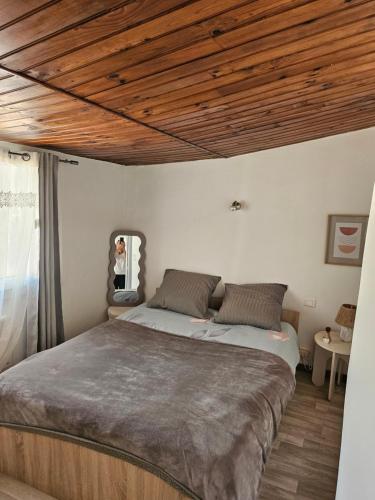 une chambre avec un grand lit avec un plafond en bois dans l'établissement agréable T2 au centre ville, à Manosque