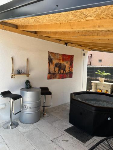 a patio with a hot tub and two stools at Elephant House-Sd 