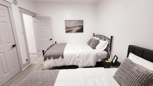 a white bedroom with a bed and a window at Grand Manor - Big 2 Bedroom - USA Side in Niagara Falls
