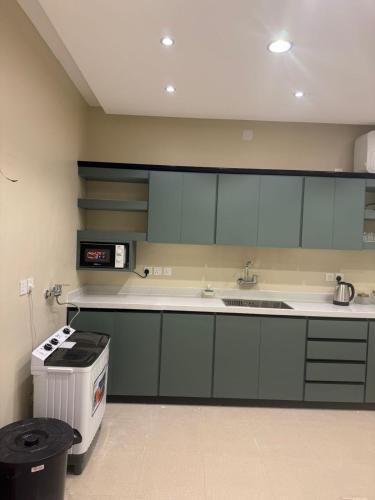 a kitchen with green cabinets and a trash can at قمم الخضراء 