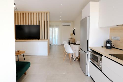 イアリソスにあるOlympian Apartmentsのキッチン、リビングルーム(テレビ、テーブル付)