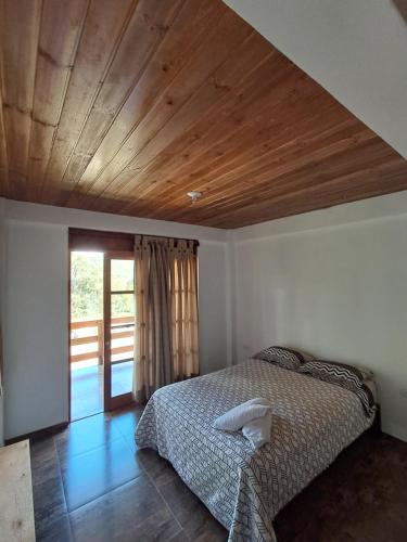 a bedroom with a bed and a wooden ceiling at Bellavista Hospedaje Vista asombrosa in Oxapampa