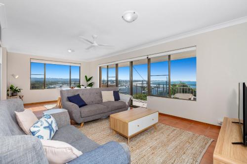 a living room with couches and a tv and windows at Sea Gaze 4 - With Remarkable Ocean Views in Kingscliff