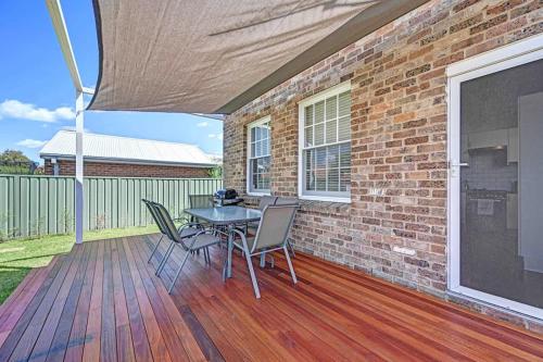 a patio with a table and chairs and a brick wall at Prince Street Cottage - 1890’s Edwardian Gem in Orange