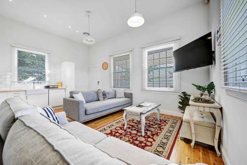 a living room with a couch and a tv at Prince Street Cottage - 1890’s Edwardian Gem in Orange