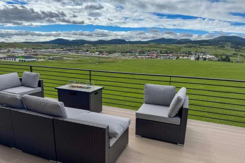a balcony with chairs and a table and a view of a field at Motorcycle-Themed Home in Spearfish with Hot Tub! in Spearfish