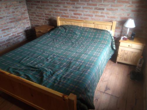 a bedroom with a bed and a brick wall at Doña Mecha in Santa Rosa de Calamuchita