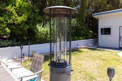 a bird cage in a yard with two chairs at Feel At Home In MV - 'Good Vibes Only' Mentality in Mission Viejo