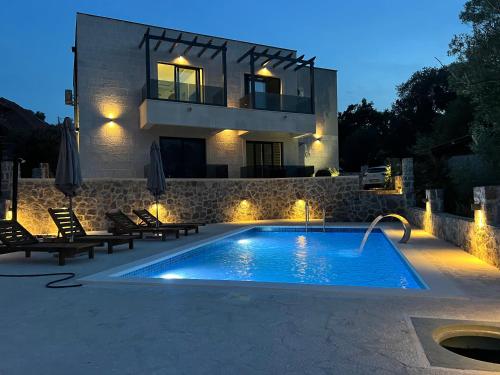 a swimming pool in front of a house at night at Casa Bellavista in Tivat