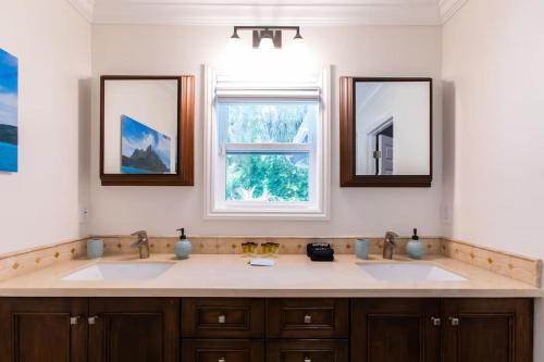 a bathroom with two sinks and two mirrors at Feel At Home In MV - 'Good Vibes Only' Mentality in Mission Viejo