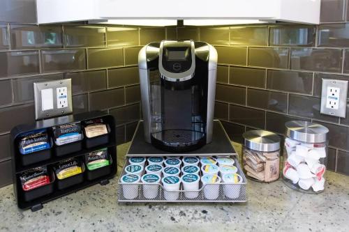 a coffee maker sitting on top of a counter with cupcakes at Feel At Home In MV - 'Good Vibes Only' Mentality in Mission Viejo