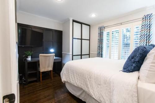 a bedroom with a bed and a desk and a television at Feel At Home In MV - 'Good Vibes Only' Mentality in Mission Viejo