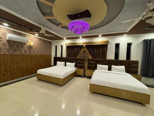 a bedroom with two beds and a chandelier at Islamabad Family Residence in Islamabad