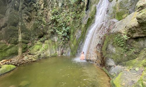 a waterfall in a pool of water with a person in it at Kasaurora in Tobia