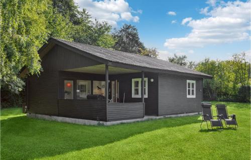 a small house with two chairs in a yard at 2 Bedroom Gorgeous Home In Askeby in Askeby