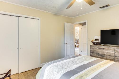 a bedroom with a bed and a flat screen tv at 1 Mi to Dtwn Waycross Home with Furnished Porch in Waycross