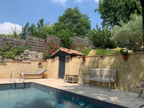 un patio avec deux bancs et une piscine dans l'établissement Les 5 terrasses - vue imprenable et piscine privée, à La Sauvetat