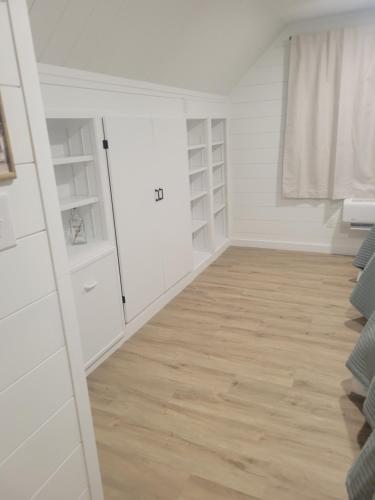 a room with white cabinets and a wooden floor at Adventure Awaits in Beaufort