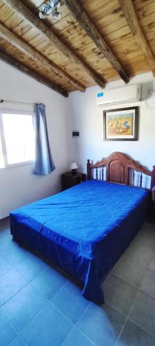 a bedroom with a large blue bed in a room at Cabaña Cecilia in Villa Icho Cruz