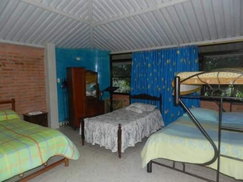 a bedroom with two beds and blue walls at Casa con Piscina cerca a Neiva 1 in Palermo