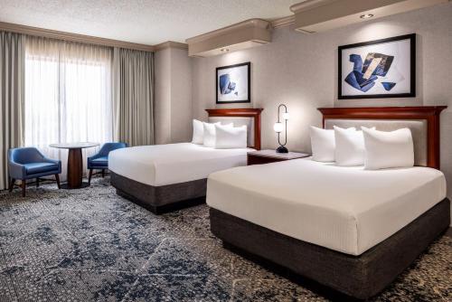 a hotel room with two beds and a table and chairs at Harrah's Joliet, A Caesars Destination in Joliet