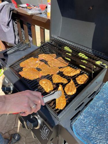 a person is cooking hamburgers on a grill at Willa Garian in Woryty