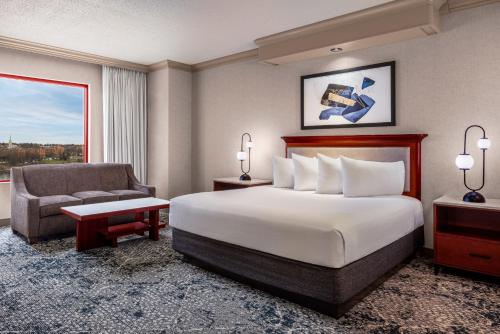 a hotel room with a bed and a chair at Harrah's Joliet, A Caesars Destination in Joliet
