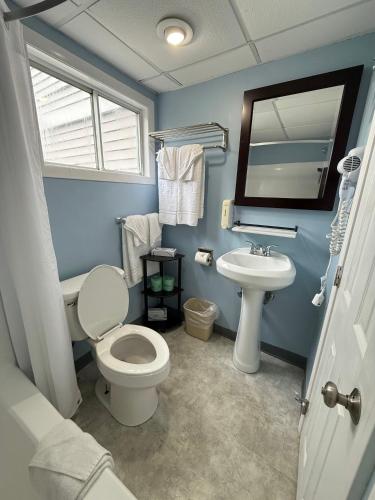 a blue bathroom with a toilet and a sink at Cape Sands Inn in West Yarmouth