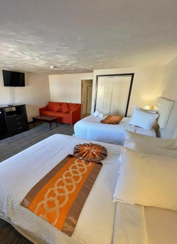 a hotel room with two beds and a couch at Cape Sands Inn in West Yarmouth
