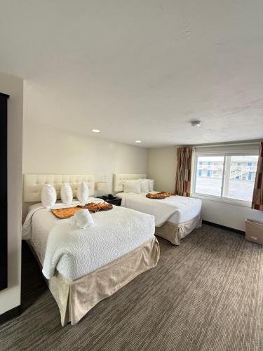 a hotel room with two beds and a window at Cape Sands Inn in West Yarmouth