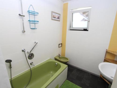 a bathroom with a green tub and a toilet and a sink at Yannsa in Untertweng