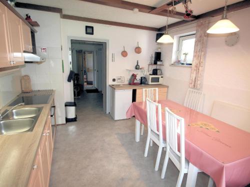 a kitchen with a pink table and chairs in it at Yannsa in Untertweng