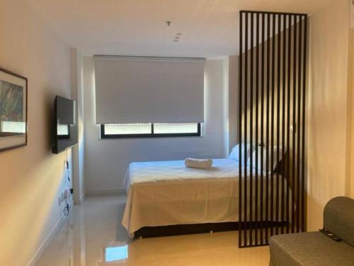 a bedroom with a bed and a window at Flat moderno Garagem AR cond Jardim Amália VR in Volta Redonda