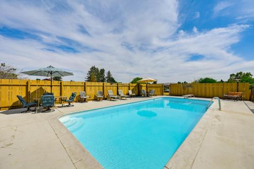 a swimming pool with chairs and an umbrella at Family-Friendly Yakima Escape with Yard and Pool! in Yakima