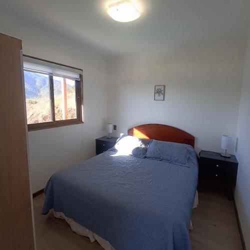 a bedroom with a blue bed and a window at Asclepia lodge spa in Quebrada Escobares