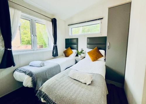 two beds in a room with two windows at Hideaway by Liv Retreats in Lincoln