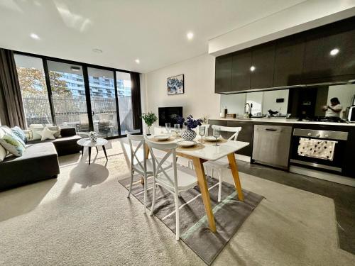 a kitchen and living room with a table and chairs at Urban Surf Garden Hideaway in Sydney