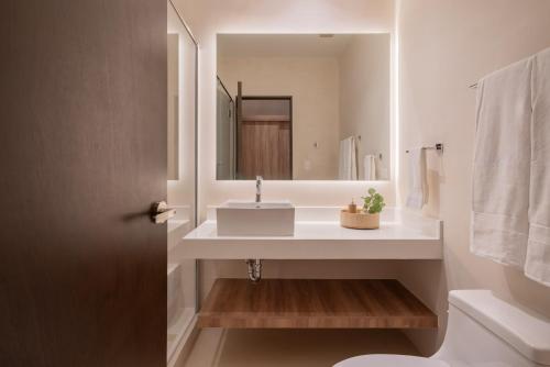 a bathroom with a sink and a mirror at Kune in Tulum